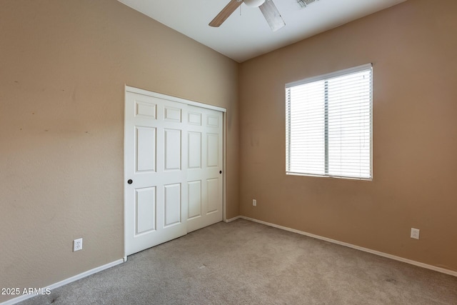 unfurnished bedroom with light carpet, a closet, and ceiling fan