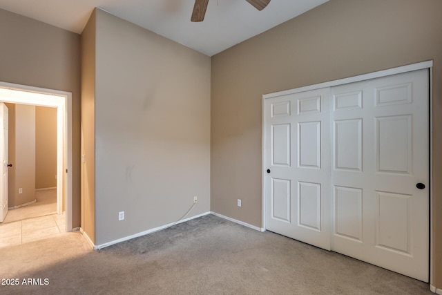 unfurnished bedroom with ceiling fan, a closet, and light colored carpet