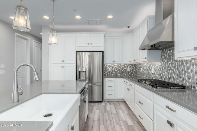 1848 S Follett Way, Gilbert, AZ 85295 - kitchen with stainless steel appliances, a sink, wall chimney exhaust hood, white cabinets, and recessed lighting