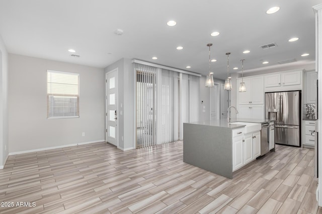1848 S Follett Way, Gilbert, AZ 85295 - kitchen with stainless steel appliances, light wood finished floors, white cabinetry, recessed lighting, and a sink