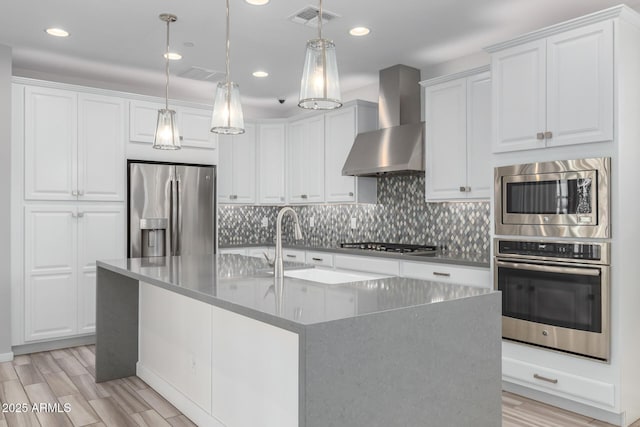 1848 S Follett Way, Gilbert, AZ 85295 - kitchen featuring stainless steel appliances, wall chimney range hood, tasteful backsplash, light wood finished floors, and white cabinetry