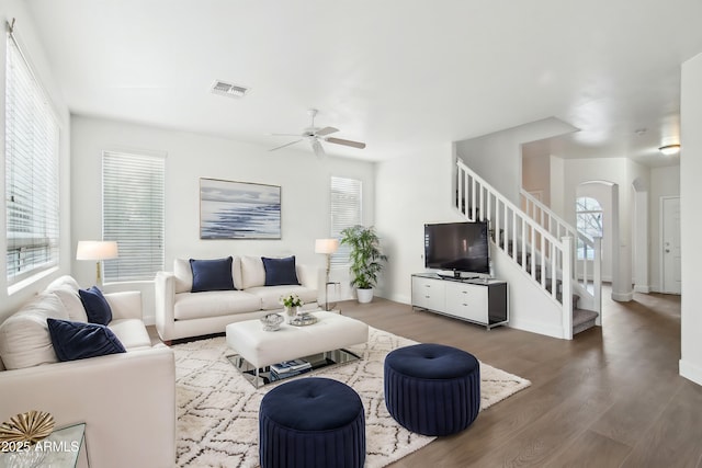 living room featuring ceiling fan and dark hardwood / wood-style flooring