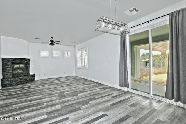 unfurnished living room featuring ceiling fan, a fireplace, and wood-type flooring