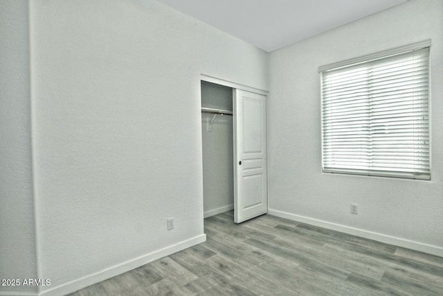 unfurnished bedroom with light hardwood / wood-style flooring and a closet