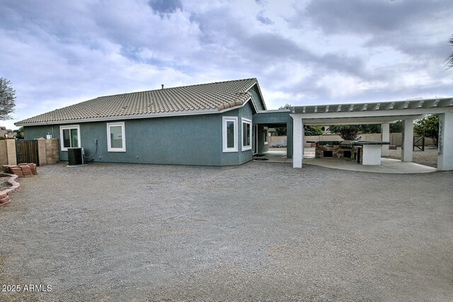 back of property featuring exterior kitchen, a patio area, and central air condition unit