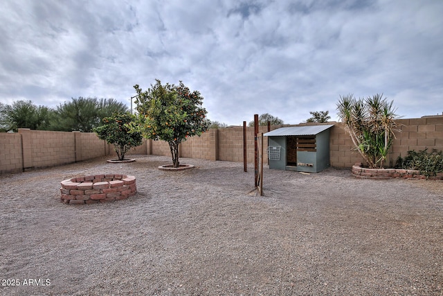 view of yard featuring a fire pit and an outdoor structure