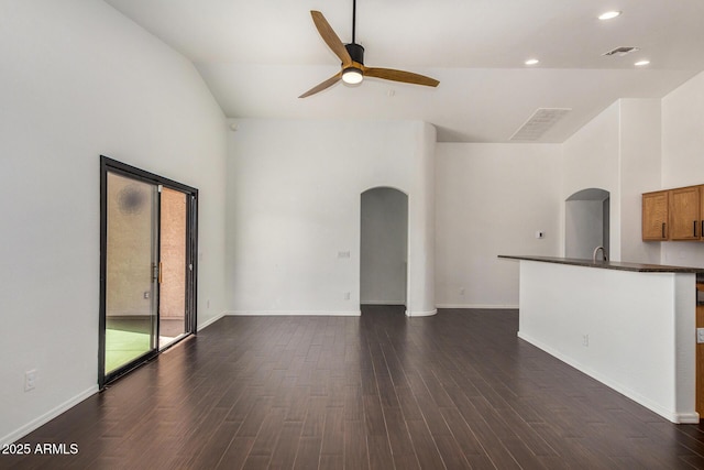 unfurnished living room featuring dark wood-type flooring, ceiling fan, and sink