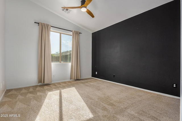 spare room featuring light carpet, vaulted ceiling, and ceiling fan