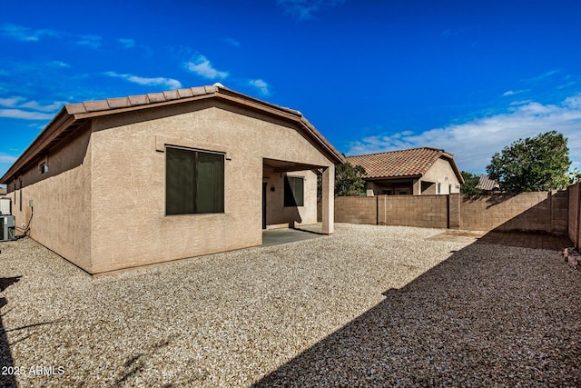 rear view of house with cooling unit and a patio