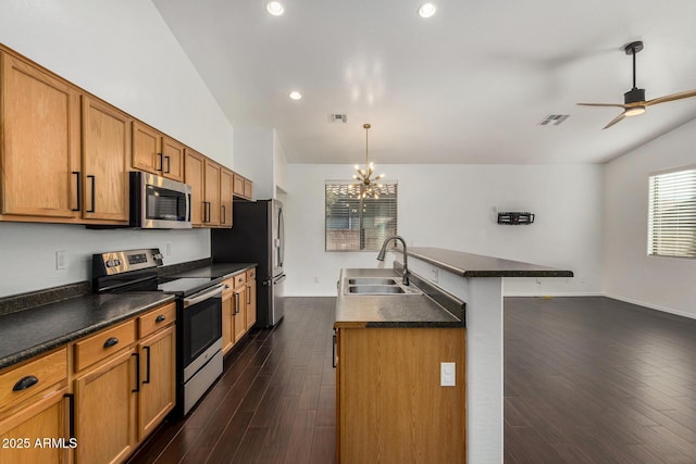 kitchen with sink, a wealth of natural light, stainless steel appliances, and hanging light fixtures