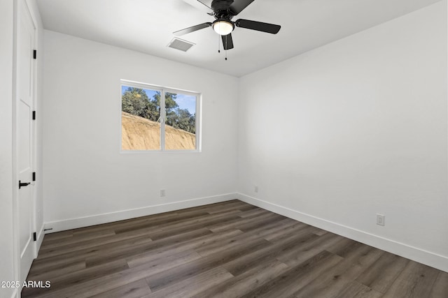 spare room featuring dark wood-type flooring and ceiling fan