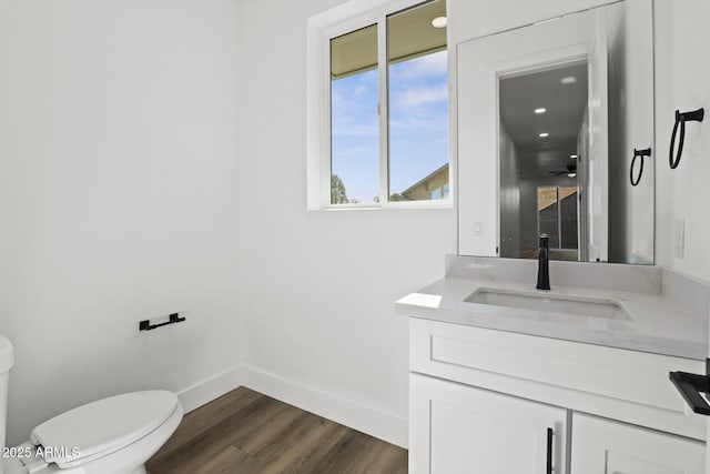 bathroom featuring vanity, hardwood / wood-style floors, and toilet