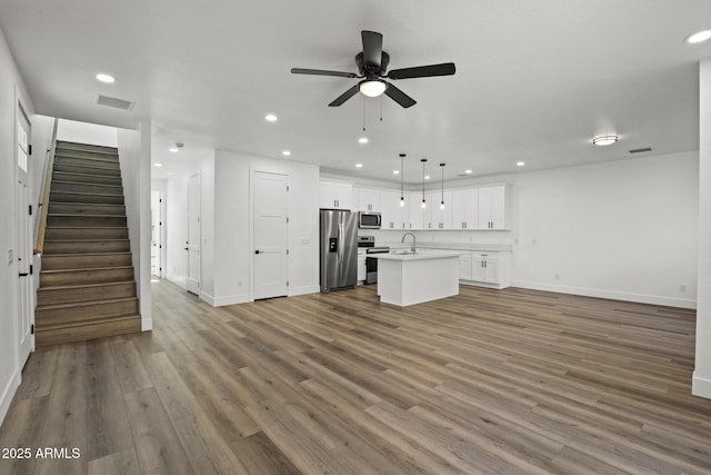 unfurnished living room with sink, dark wood-type flooring, and ceiling fan