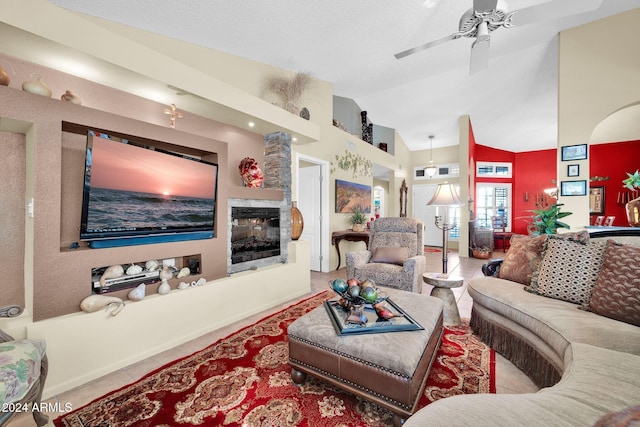 tiled living room with a fireplace, a textured ceiling, high vaulted ceiling, and ceiling fan