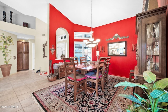 tiled dining room with a chandelier and high vaulted ceiling