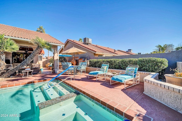 view of swimming pool with a patio area, an in ground hot tub, and cooling unit