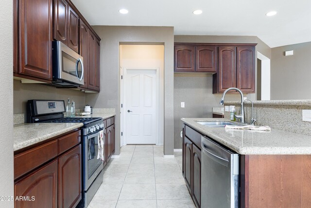 2003 Valley Sage St, Sierra Vista, AZ 85635 - kitchen featuring appliances with stainless steel finishes, a sink, light tile patterned floors, light stone countertops, and recessed lighting