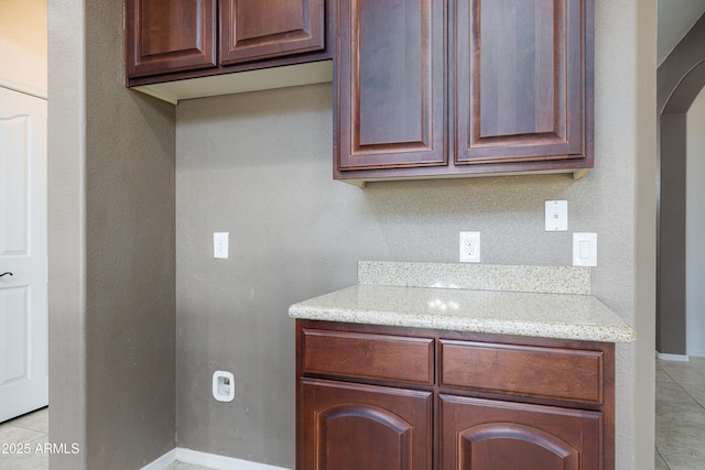 2003 Valley Sage St, Sierra Vista, AZ 85635 - kitchen with arched walkways, baseboards, light stone counters, and light tile patterned floors