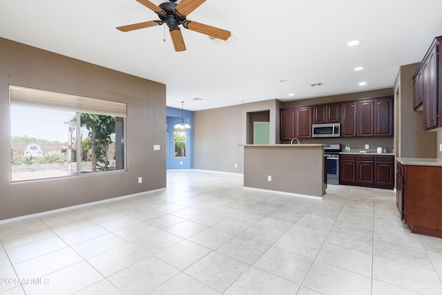 2003 Valley Sage St, Sierra Vista, AZ 85635 - kitchen with stainless steel appliances, light countertops, open floor plan, a ceiling fan, and light tile patterned floors