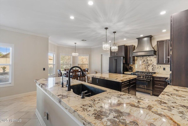 kitchen with sink, custom range hood, backsplash, a center island with sink, and high quality appliances