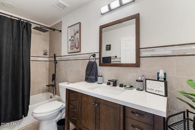 full bathroom featuring toilet, vanity, shower / bath combo, and tile walls