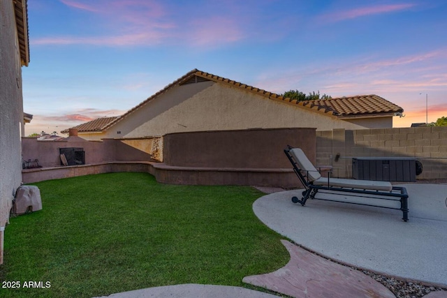 yard at dusk featuring a patio area