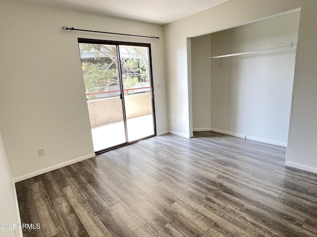 4850 E Desert Cove Ave Unit 241, Scottsdale, AZ 85254 - unfurnished bedroom with access to exterior, wood finished floors, baseboards, and a closet