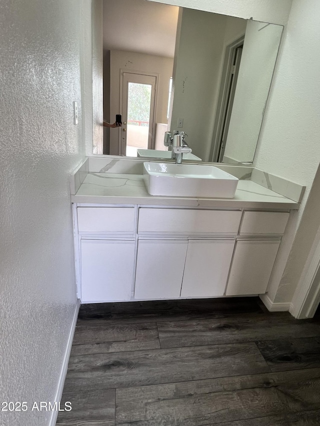 4850 E Desert Cove Ave Unit 241, Scottsdale, AZ 85254 - bathroom with vanity, wood finished floors, baseboards, and a textured wall
