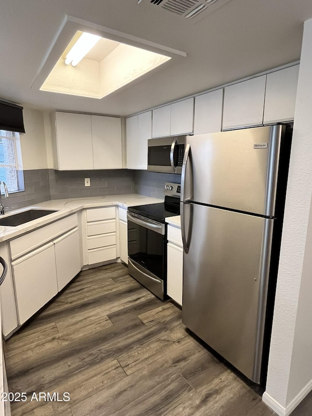 4850 E Desert Cove Ave Unit 241, Scottsdale, AZ 85254 - kitchen featuring appliances with stainless steel finishes, a sink, light countertops, dark wood-type flooring, and white cabinets