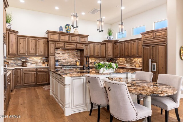 kitchen featuring dark stone countertops, a kitchen island, pendant lighting, and tasteful backsplash