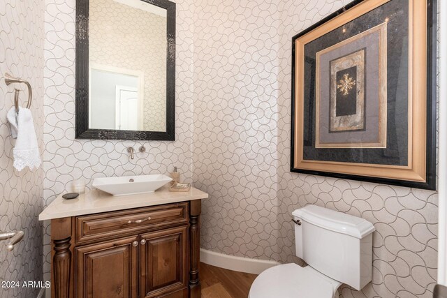 bathroom featuring vanity, toilet, and hardwood / wood-style flooring