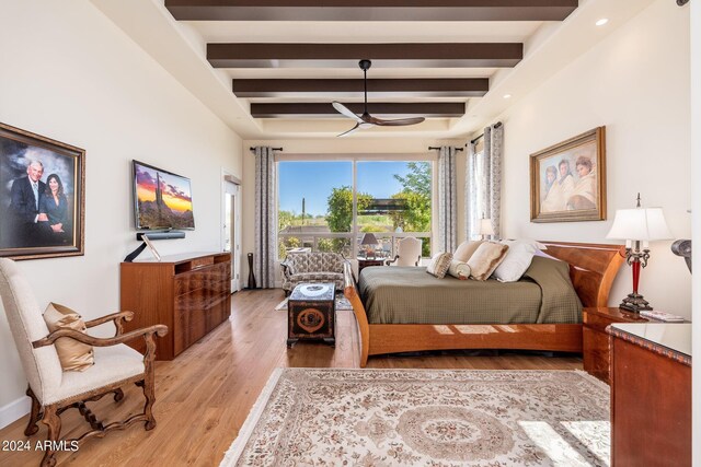 bedroom with light hardwood / wood-style flooring and beam ceiling