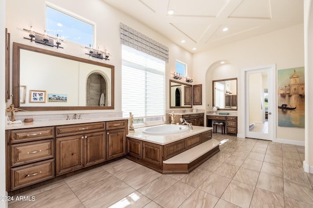 bathroom with a tub to relax in, a high ceiling, and vanity