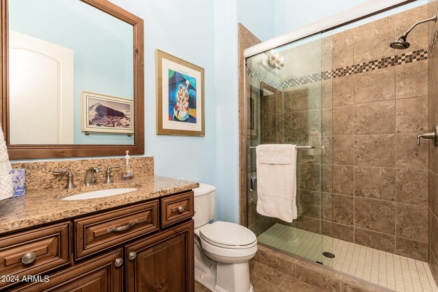 bathroom with walk in shower, vanity, and toilet