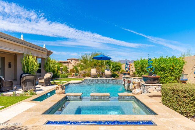 view of pool with pool water feature, an in ground hot tub, and a patio area