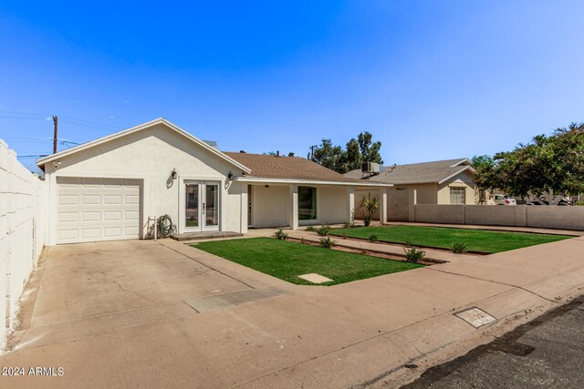 ranch-style home featuring a garage and a front lawn