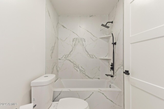 bathroom featuring toilet and tiled shower / bath combo