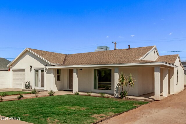 single story home featuring a garage and a front lawn