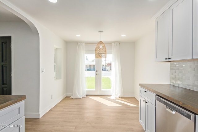 kitchen featuring butcher block countertops, dishwasher, decorative backsplash, and white cabinetry