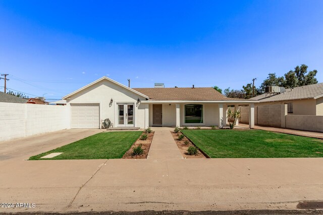 ranch-style home featuring a garage and a front lawn