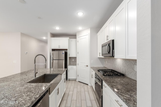 22507 E Quintero Rd, Queen Creek, AZ 85142 - kitchen featuring appliances with stainless steel finishes, decorative backsplash, white cabinetry, recessed lighting, and dark stone countertops