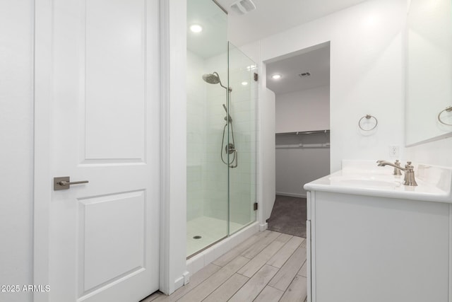 22507 E Quintero Rd, Queen Creek, AZ 85142 - bathroom featuring a stall shower, vanity, a spacious closet, and wood tiled floors
