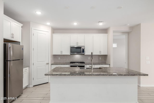 22507 E Quintero Rd, Queen Creek, AZ 85142 - kitchen featuring appliances with stainless steel finishes, backsplash, dark stone counters, white cabinets, and recessed lighting