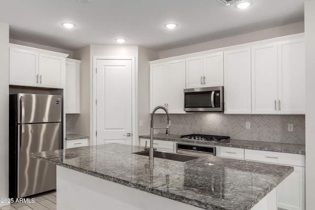 22507 E Quintero Rd, Queen Creek, AZ 85142 - kitchen with appliances with stainless steel finishes, white cabinets, decorative backsplash, dark stone countertops, and recessed lighting