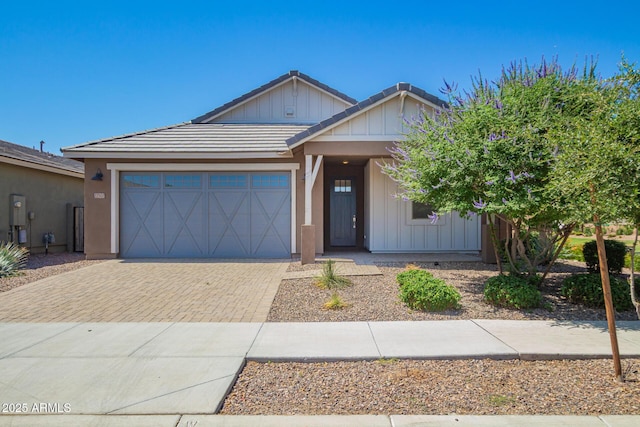 22507 E Quintero Rd, Queen Creek, AZ 85142 - view of front of home featuring decorative driveway, a garage, a tiled roof, board and batten siding, and stucco siding
