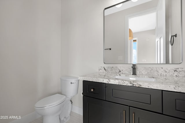 19622 W Pasadena Ave, Litchfield Park, AZ 85340 - bathroom with baseboards, vanity, and toilet