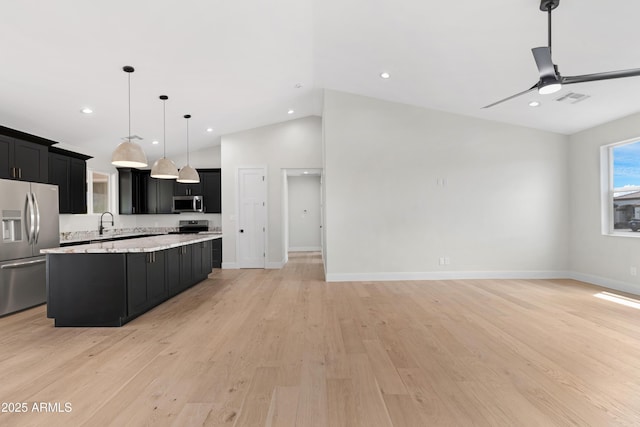 19622 W Pasadena Ave, Litchfield Park, AZ 85340 - kitchen with appliances with stainless steel finishes, dark cabinetry, open floor plan, and lofted ceiling