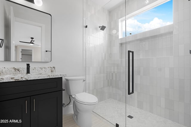 19622 W Pasadena Ave, Litchfield Park, AZ 85340 - bathroom with vanity, a tile shower, toilet, and a wealth of natural light