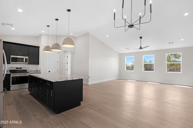19622 W Pasadena Ave, Litchfield Park, AZ 85340 - kitchen featuring dark cabinets, a center island, visible vents, and stainless steel appliances