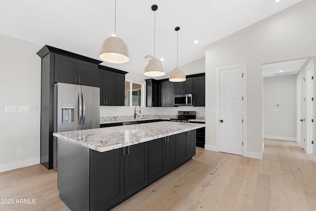 19622 W Pasadena Ave, Litchfield Park, AZ 85340 - kitchen featuring dark cabinets, a center island, stainless steel appliances, and light wood finished floors